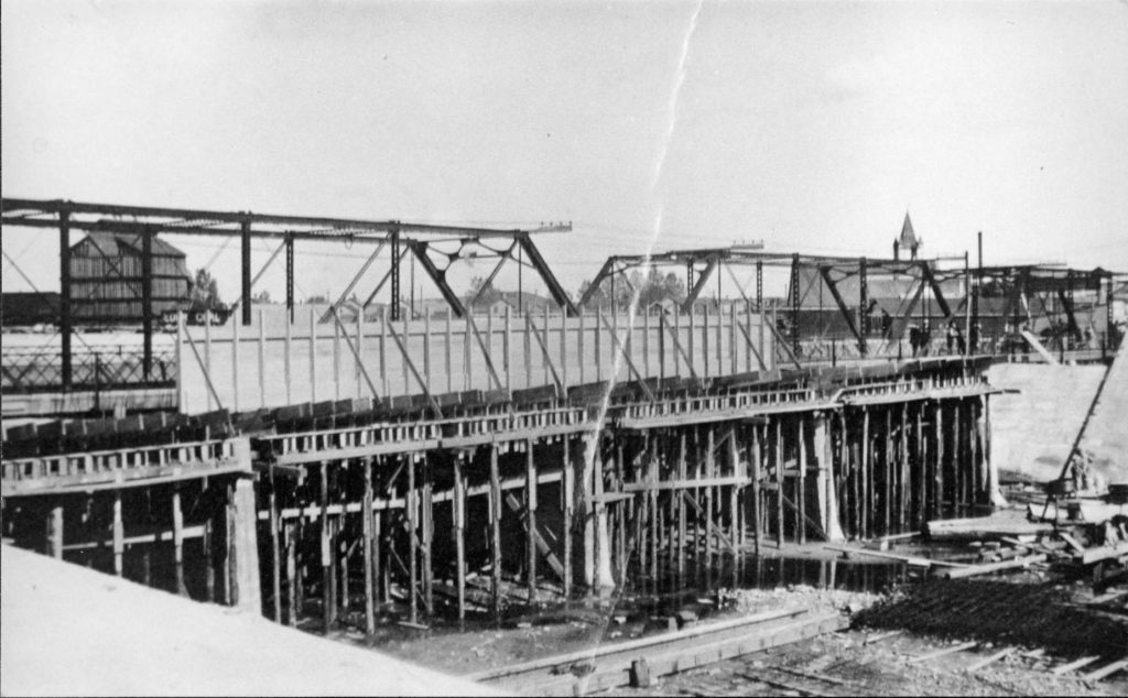 The above is an image of the early phase of construction of the siphon bridge showing remnants of the iron bridge.