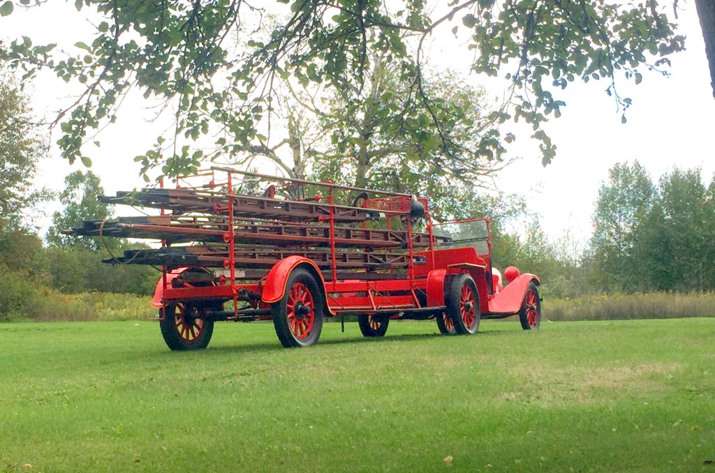 Pictured above is Manistique’s 1880’s hook and ladder wagon which responded to the fire of 1893. The horse drawn hook and ladder was married to a 1914 Dodge chemical truck by city workers in the fall of 1929.