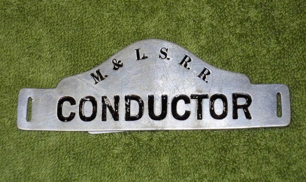 Manistique and Lake Superior Railroad conductor hat badge donated by Gregory R. Miller (2015)